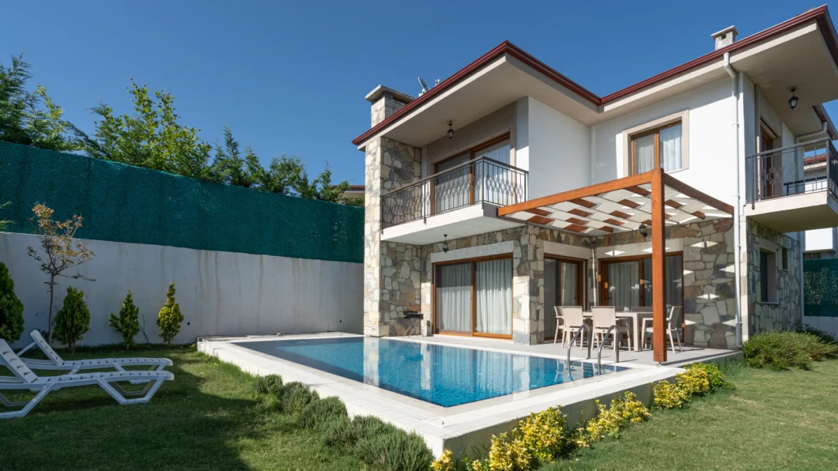 Güneşli havada villa ve havuzun geniş açıdan görünümü